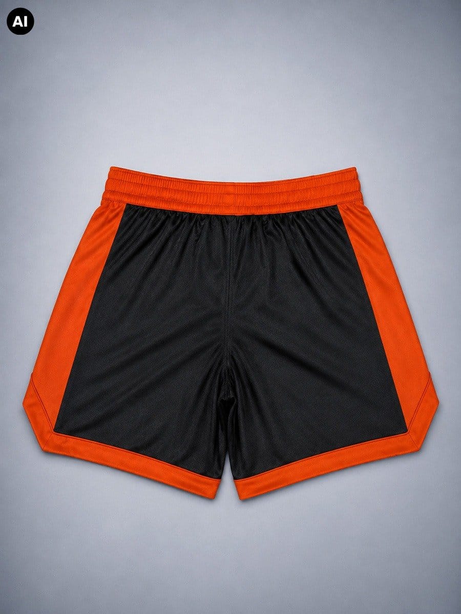 Schwarze Shorts mit orangefarbenen Seitenstreifen und elastischem Bund, liegend auf einem grauen Hintergrund.